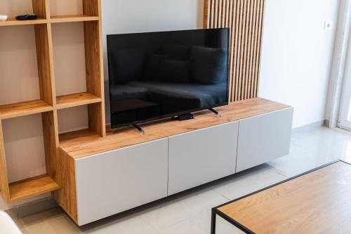a flat screen tv sitting on a entertainment center at Olivia's Apartments in Velipojë
