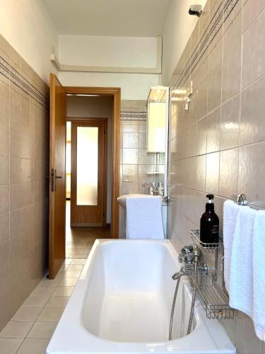 Una bañera blanca en un baño con lavabo. en La Casa Del Mare, en Torre del Lago Puccini