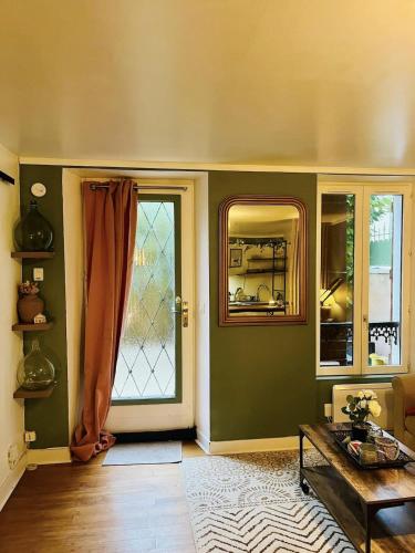 - un salon avec des murs verts et une porte dans l'établissement Le Cocon Bellifontain - Appartement Confort - Proche Centre Ville, à Fontainebleau