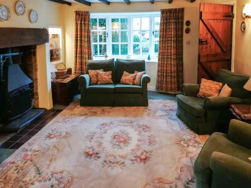 a living room with couches and a fireplace at Lilac Cottage in Sinnington