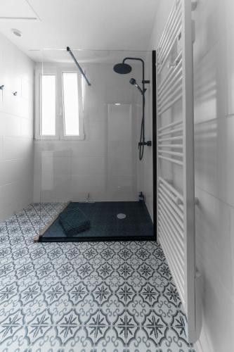La salle de bains est pourvue d'une douche et de carrelage. dans l'établissement Le 108 - Appartement design, 2 chambres, quartier Thermal, à Vichy