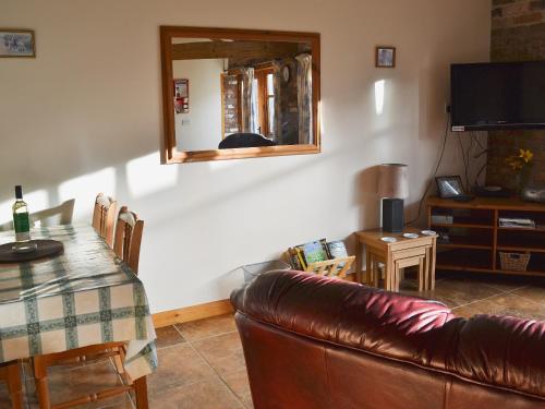 a living room with a couch and a table and a mirror at Ploughman's Cottage in Flamborough