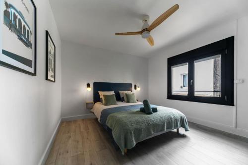 une chambre avec un lit et un ventilateur de plafond dans l'établissement Le 108 - Appartement design, 2 chambres, quartier Thermal, à Vichy