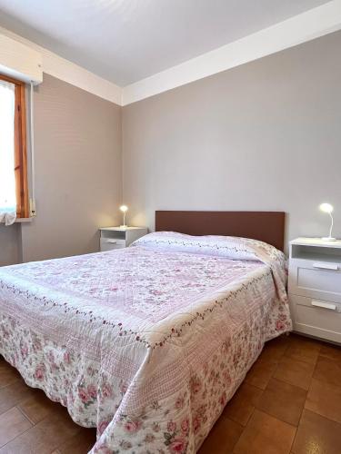 1 dormitorio con 1 cama con colcha rosa en La Casa Del Mare, en Torre del Lago Puccini