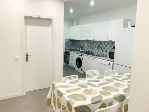 uma cozinha com mesa e cadeiras e uma cozinha com fogão em Casas Sao Luis em Faro