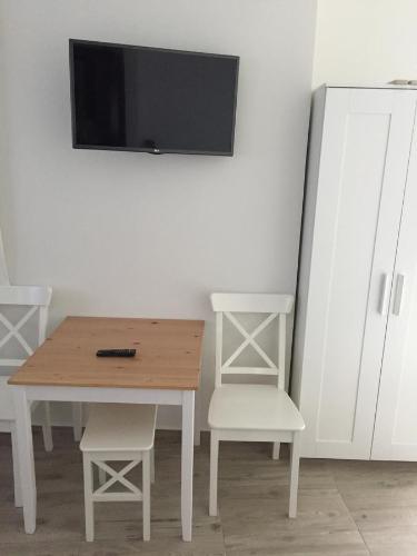a table with two chairs and a television on a wall at Amalthia Luxury Studios in Naxos Chora