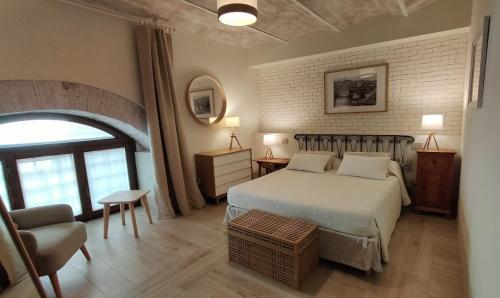 Un dormitorio con una cama y una silla y una ventana. en Porta Fiorentina Home, en Castiglion Fiorentino