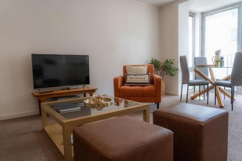 a living room with a flat screen tv and chairs at Elegant Retreat Carnoustie in Angus