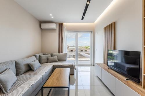 a living room with a couch and a tv at Olivia's Apartments in Velipojë