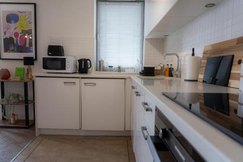 a kitchen with white cabinets and a microwave at Elegant Retreat Carnoustie in Angus