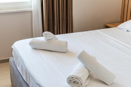 a hotel room with two rolled towels on a bed at Olivia's Apartments in Velipojë