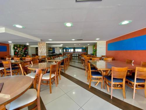 a dining room with tables and chairs in a restaurant at Imperial Flat 111 Beira Mar Tambaú in João Pessoa