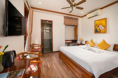 a hotel room with a bed and a television at Rony Retreat Villas in Hoi An