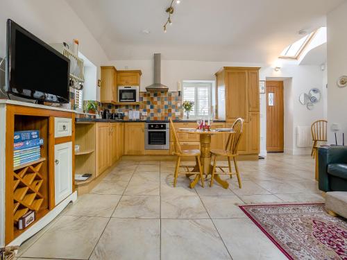 a kitchen with a table and a dining room at Appletree Cottage in Kirkton of Tealing