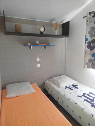 - une chambre avec 2 lits et une horloge murale dans l'établissement Mobilhome avec terrasse couverte à 800 m de la plage, à Saint-Cast-le-Guildo