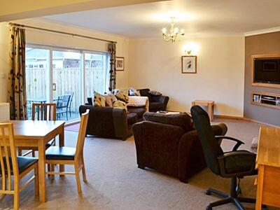 ein Wohnzimmer mit Sofa und Tisch in der Unterkunft Willow Cottage in Hadston