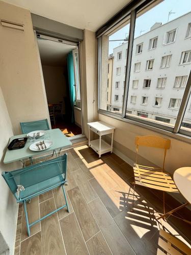 une pièce avec une table, des chaises et une fenêtre dans l'établissement 2 chambres, garage voiture, résidence calme, à Villeurbanne