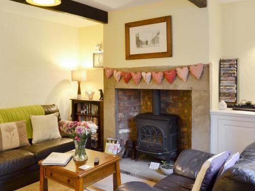 ein Wohnzimmer mit Kamin und Couch in der Unterkunft Park View Cottage in Old Glossop