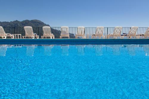 a group of chairs sitting next to a swimming pool at Hotel Graal in Ravello