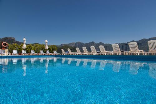 a large swimming pool with chairs and blue water at Hotel Graal in Ravello