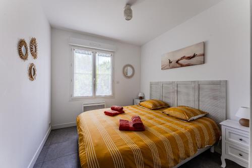 - une chambre dotée d'un lit avec deux chaussures rouges dans l'établissement Pretty house with pool and large terrace - Bassin d'Arcachon, à Arès