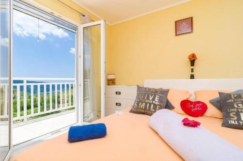 a bedroom with a bed and a large window at Family-friendly apartments with swimming pool Vodovadja, Dubrovnik - 24632 in Dubravka
