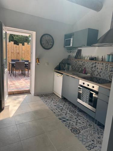 une cuisine avec une table et une horloge au mur dans l'établissement Maset Lou Pitchoun, à Saint-Rémy-de-Provence