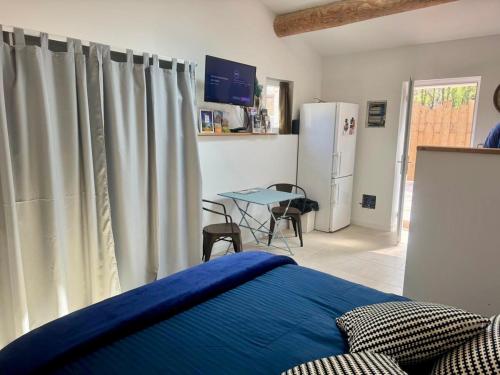 - une chambre avec un lit, une table et un réfrigérateur dans l'établissement Maset Lou Pitchoun, à Saint-Rémy-de-Provence
