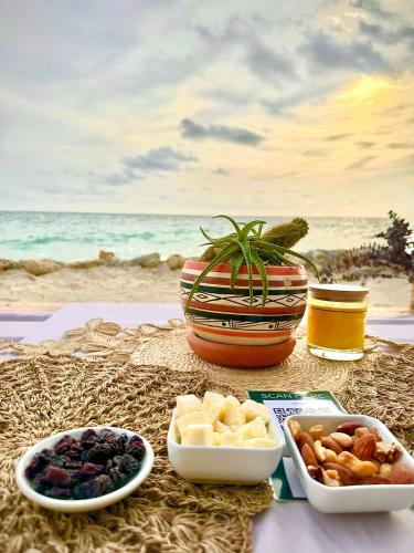 a table with bowls of food on the beach at Thani Ecobeach Barú in Playa Blanca