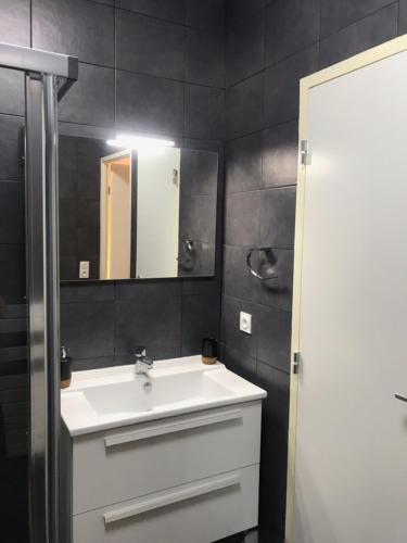 une salle de bain avec un lavabo blanc et un miroir dans l'établissement Linda - Spacious 1Br Modern Terrace - by TGB, à Ajaccio
