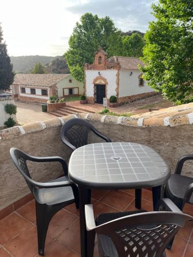 a table and chairs on a balcony with a view of a building at Casa del Ermitaño in Ossa de Montiel
