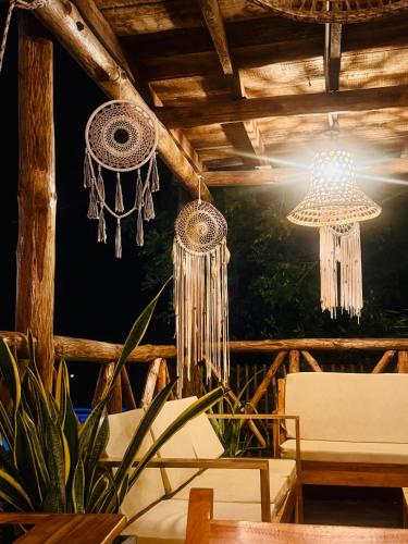 a room with chandeliers hanging from a wooden ceiling at Thani Ecobeach Barú in Playa Blanca