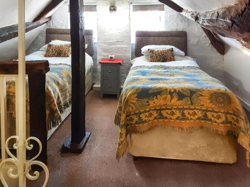 a bedroom with two beds and a table with a night stand at Childe Of Hale Cottage - 27896 in Hale