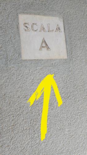 a sign on a wall with a yellow arrow at A casa di Erica in Sorrento
