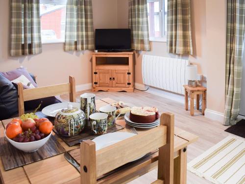 a living room with a table with fruit on it at Pheasant Lodge in Staithes