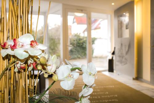 a vase filled with white flowers in a hallway at Hotel Goldenes Fass in Rothenburg ob der Tauber in Rothenburg ob der Tauber