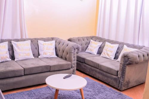 a living room with a couch and a table at Decy Homes in Ruaka