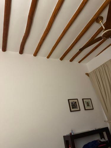 Cette chambre est dotée de murs blancs et de poutres apparentes. dans l'établissement Roses 1, à Paris