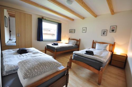een slaapkamer met 2 bedden en een raam bij Jungfrau Views Apartment in Interlaken