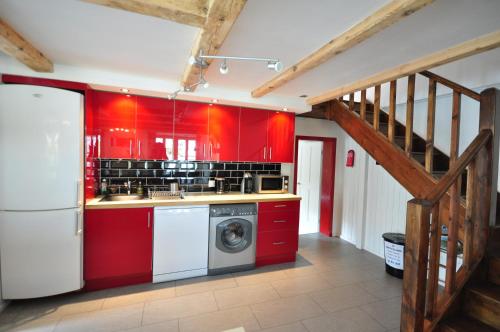 a kitchen with red cabinets and a washing machine at Jungfrau Views Apartment in Interlaken