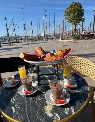 a table with a tray of pastries and cups of coffee at Casa Sana sur le port in Sanary-sur-Mer