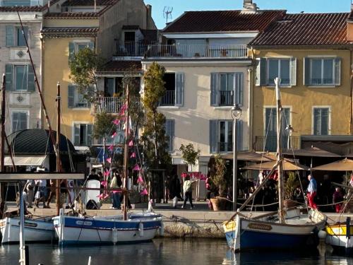 a group of boats docked in the water in front of buildings at Casa Sana sur le port in Sanary-sur-Mer