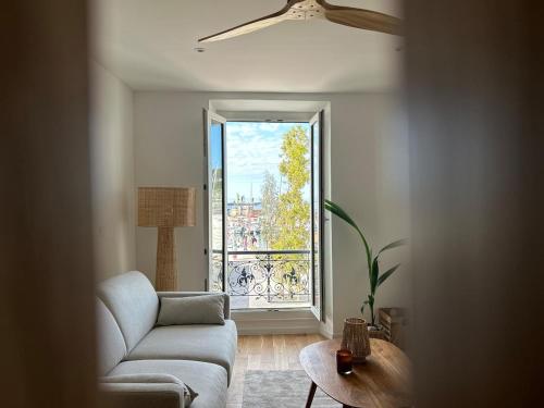 a living room with a couch and a large window at Casa Sana sur le port in Sanary-sur-Mer