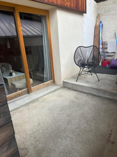 ein schwarzer Stuhl vor einem Haus in der Unterkunft Appartement Confort 2 Chambres Serre Chevalier in Saint-Chaffrey