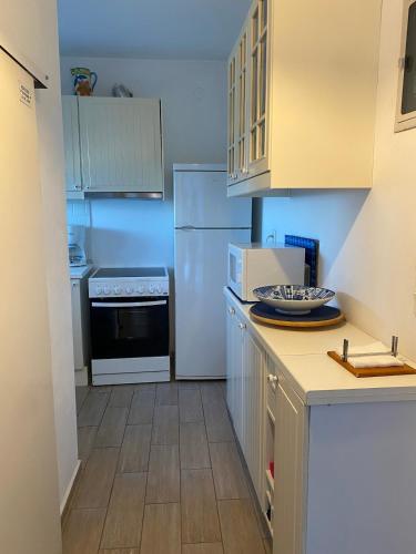 a kitchen with white appliances and wooden floors at House on the beach in Skiros
