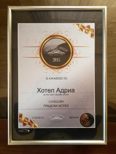 a framed diploma frame with a bottle of kochin apolloolloolloollo at Hotel Adria in Sofia