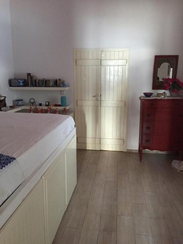 a bedroom with a bed and a red dresser at House on the beach in Skiros