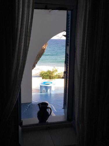 a view of the beach from a window with a vase at House on the beach in Skiros
