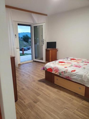 a bedroom with a bed and a sliding glass door at Casa Maya & Cristi in Orşova