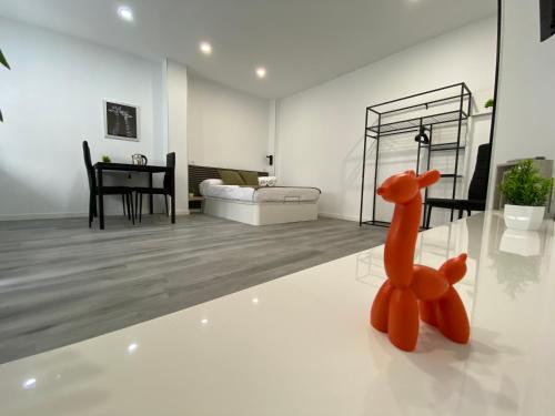 a orange toy animal sitting on the floor of a living room at Loft La Jirafa in Las Palmas de Gran Canaria